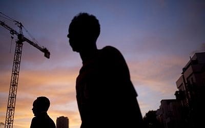 In this April 3, 2018, photo, African migrants cross a street in southern Tel Aviv. (AP Photo/Ariel Schalit)