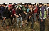 Palestinian protesters evacuate a wounded youth during clashes with Israeli troops along Gaza's border with Israel, east of Khan Younis, Gaza Strip, April 5, 2018. (AP Photo/Adel Hana)