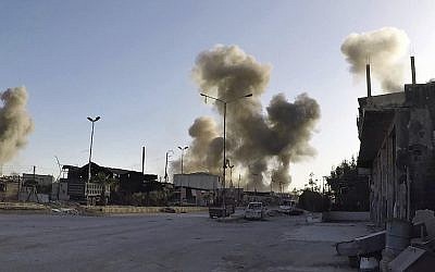 This photo released by the Syrian Civil Defense White Helmets, which has been authenticated based on its contents and other AP reporting, shows smoke rising after Syrian government airstrikes hit in the town of Douma, in the Eastern Ghouta region east of Damascus, Syria, on April 7, 2018. (Syrian Civil Defense White Helmets via AP)