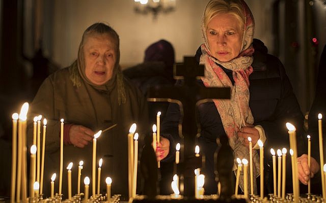 Lithuanian Orthodox believers light candles during an Easter vigil mass in the Orthodox Church of the Holy Spirit in Vilnius, Lithuania, April 7, 2018. (AP Photo/Mindaugas Kulbis)
