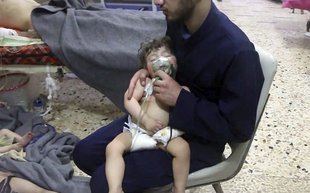 This image made from video released by the Syrian Civil Defense White Helmets, which has been authenticated based on its contents and other AP reporting, shows a medical worker giving toddlers oxygen through respirators following an alleged poison gas attack in the opposition-held town of Douma, in eastern Ghouta, near Damascus, Syria,  April 8, 2018. (Syrian Civil Defense White Helmets via AP)