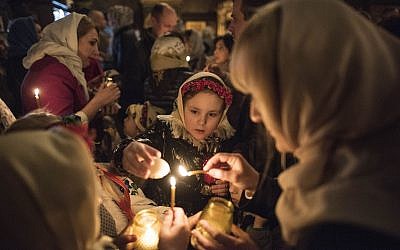 Ukrainian Orthodox believers light candles from the Holy Fire during Orthodox Easter celebrations in the Volodymyrskiy Monastery in Kiev, Ukraine, April 7, 2018. (AP Photo/ Evgeniy Maloletka)
