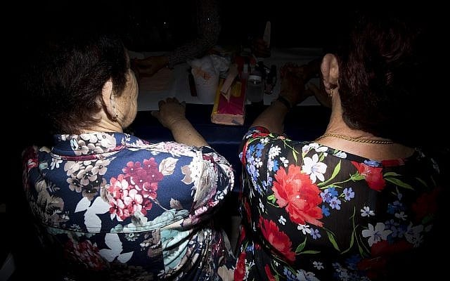 Two holocaust survivors has fingernail polish applied during a Beauty Heroines event in Ramat Gan, Israel, Monday, April 9, 2018. (AP Photo/Oded Balilty)