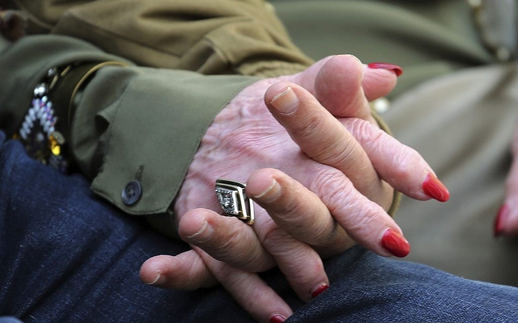 In this Wednesday, April 11, 2018, photo, childhood Holocaust survivors Simon Gronowski and Alice Gerstel Weit join their hands as they are interviewed at the Los Angeles Holocaust Museum memorial following their reunion after more than 70 years. (AP Photo/Reed Saxon)