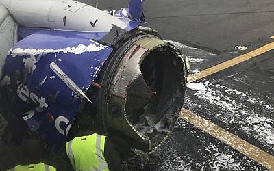 The engine on a Southwest Airlines plane is inspected as it sits on the runway at the Philadelphia International Airport after it made an emergency landing in Philadelphia, April 17, 2018. (Amanda Bourman via AP)