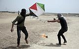 Illustrative: Palestinian protesters fly a kite with a burning rag dangling from its tail, during a protest at the Gaza Strip's border with Israel, April 20, 2018. (AP Photo/Khalil Hamra)