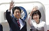 Japanese Prime Minister Shinzo Abe, left, waves with his wife Akie Abe while boarding his plane before departure for the Middle East, at Haneda international airport in Tokyo April 29, 2018. (Yukie Nishizawa/Kyodo News via AP)