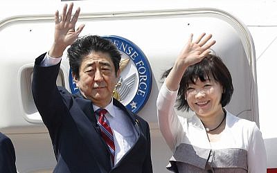 Japanese Prime Minister Shinzo Abe, left, waves with his wife Akie Abe while boarding his plane before departure for the Middle East, at Haneda international airport in Tokyo April 29, 2018. (Yukie Nishizawa/Kyodo News via AP)