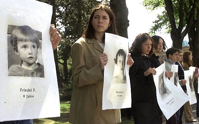 Illustrative: Young people hold pictures of children murdered at the city hospital under the Nazi euthanasia program of the physically or mentally handicapped, and their brains and other remains then used for decades for medical research, during a public service in Vienna's Central Cemetery where the last two specimens are buried, April 28, 2002. (AP Photo/Ronald Zak) Illustrative: Young people hold pictures of children murdered at the city hospital under the Nazi euthanasia program of the physically or mentally handicapped, and their brains and other remains then used for decades for medical research, during a public service in Vienna's Central Cemetery where the last two specimens are buried, April 28, 2002. (AP Photo/Ronald Zak)