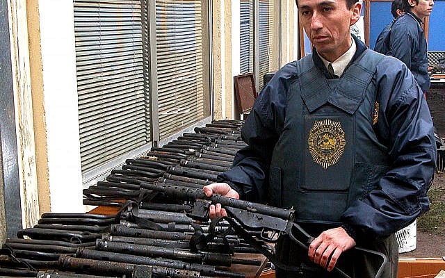 An officer stands by a large arms cache found by Chilean authorities at the commune-like Colonia Dignidad, or Dignity Colony, is displayed in Parral, Chile, some 410 kilometers (255 miles) south of Santiago, Wednesday, June, 15, 2005. (AP Photo) An officer stands by a large arms cache found by Chilean authorities at the commune-like Colonia Dignidad, or Dignity Colony, is displayed in Parral, Chile, some 410 kilometers (255 miles) south of Santiago, Wednesday, June, 15, 2005. (AP Photo)