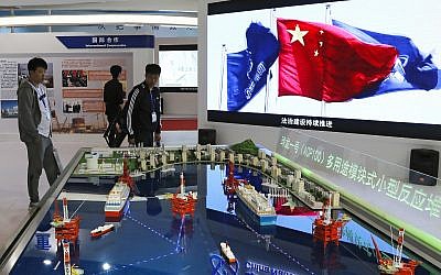 Visitors look at the models of oil tanker shaped floating nuclear reactors and oil rigs showcased at the display booth of China's state-owned China National Nuclear Corporation during the China International Exhibition on Nuclear Power Industry in Beijing, Thursday, April 27, 2017. AP Photo/Andy Wong)