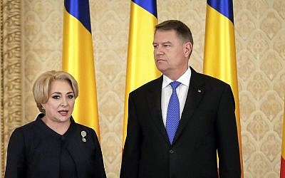 Romanian Prime Minister Viorica Dancila, left, stands next to Romania's President Klaus Iohannis after the swearing in of her cabinet, in Bucharest, Romania, Monday, January 29, 2018. (AP Photo/Vadim Ghirda)
