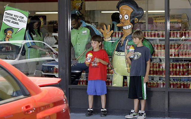 Children pause next to a poster with "The Simpsons" character Apu Nahasapeemapetilon Jr. outside a 7-Eleven Kwik-E-Mart in Burbank, California. (AP Photo/Damian Dovarganes, File) Children pause next to a poster with "The Simpsons" character Apu Nahasapeemapetilon Jr. outside a 7-Eleven Kwik-E-Mart in Burbank, California. (AP Photo/Damian Dovarganes, File)