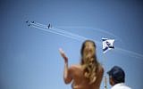 People watch as an Israeli acrobatic team fly over during Israel's 70th Independence Day celebrations, in Tel Aviv, Israel, Thursday, April 19, 2018. (AP Photo/Ariel Schalit)