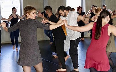 In this April 15, 2018 photo a group of people take part in a workshop, led by Syrian migrants, to learn the traditional Arabic dance Dabke in Berlin, Germany. (AP Photo/Jona Kallgren)