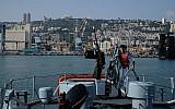 A crewmember of a Dvora patrol boat gets the ship ready in the Haifa port for the Israeli Navy's flotilla in honor of Israel's 70th Independence Day on April 19, 2018. (Judah Ari Gross/Times of Israel)