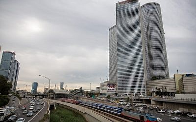 Train tracks and the Ayalon highway in central Tel Aviv, with the Azrieli Towers as a backdrop, December 18, 2017. (Miriam Alster/Flash90)