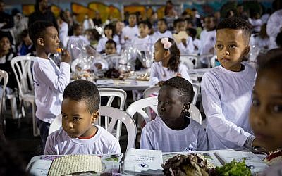 Students from Bialik School in South Tel Aviv, many of them children of African asylum-seekers, attend a pre-Passover seder in the schoolyard on March 20, 2018. (Miriam Alster/FLASH90)