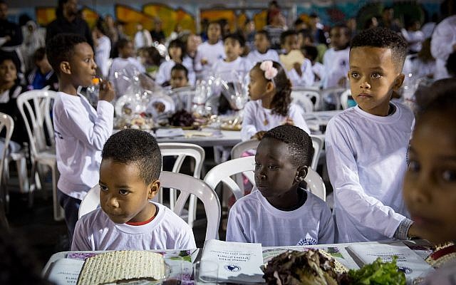 Students from Bialik School in South Tel Aviv, many of them children of African asylum-seekers, attend a pre-Passover seder in the schoolyard on March 20, 2018. (Miriam Alster/FLASH90)