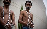 African asylum seekers set up a mock slave auction as part of a protest outside the Ministry of Defense in Tel Aviv, against their deportation, on April 3, 2018. (Miriam Alster/ Flash90)