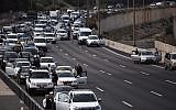 People stand still on the Ayalon highway in Tel Aviv as a two-minute siren is sounded across Israel to mark Holocaust Remembrance Day on April 12, 2018. (Miriam Alster/Flash90)