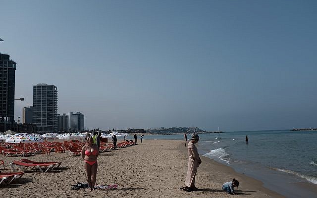 People stand still in Tel Aviv, as a two-minute siren is sounded across Israel to mark Holocaust Remembrance Day on April 12, 2018. (Tomer Neuberg/Flash90)