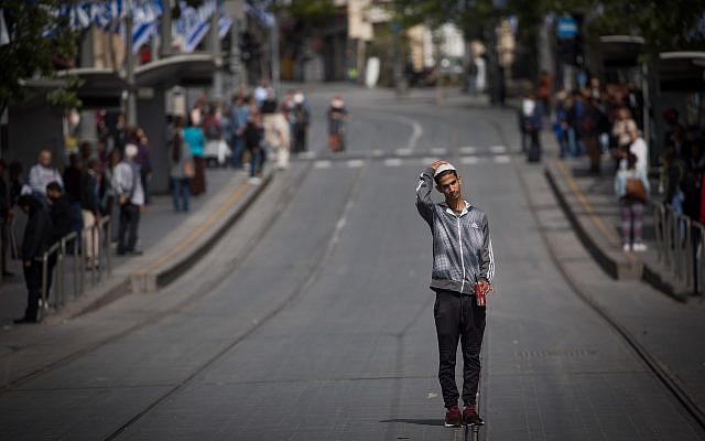 People stand still on Jaffa road, central Jerusalem, as a two-minute siren is sounded across Israel to mark Holocaust Remembrance Day on April 12, 2018. (Yonatan Sindel/Flash90)