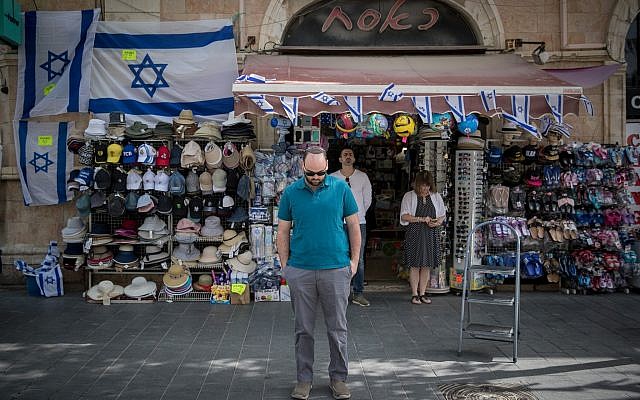 People stand still on Jaffa road, central Jerusalem, as a two-minute siren is sounded across Israel to mark Holocaust Remembrance Day on April 12, 2018. (Yonatan Sindel/Flash90)