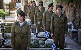 Soldiers place Israeli flags on the graves of fallen soldiers in Mount Herzl Military Cemetery in Jerusalem on April 16, 2018 ahead of Memorial Day for Israel's Fallen Soldiers. (Hadas Parush/Flash90)