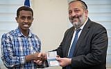 Sintayehu Shafrao from Ethiopia, who is competing in the annual International Bible Quiz in Israel, receives a National ID from Israel Minister of Interior Affairs Aryeh Deri during a ceremony at the Interior ministry office in Jerusalem on April 16, 2018. (Yonatan Sindel/Flash9)