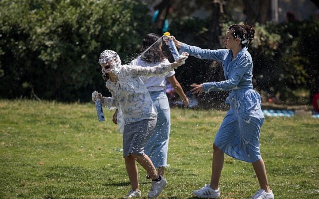 Israelis play with foam spray during Israel's 70th Independence Day celebrations in Sacher Park in Jerusalem, April 19, 2018. (Yonatan Sindel/Flash90)