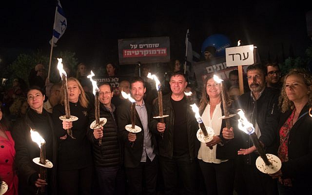 Leader of the Zionist Union party Avi Gabbay and Zionist Union MKs hold torches at a protest against attempts to enact laws that bypass the High Court of Justice and public criticism of the court's intervention in the legislative process, in Jerusalem, on April 21, 2018. (Yonatan Sindel/Flash90) Leader of the Zionist Union party Avi Gabbay and Zionist Union MKs hold torches at a protest against attempts to enact laws that bypass the High Court of Justice and public criticism of the court's intervention in the legislative process, in Jerusalem, on April 21, 2018. (Yonatan Sindel/Flash90)