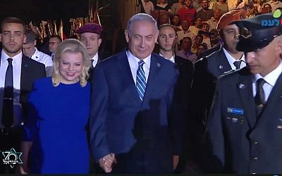 Prime Minister Benjamin Netanyahu (R) and his wife Sara arrive at the torch lighting ceremony at Mount Herzl on April 18, 2018. (Screen capture/Facebook)