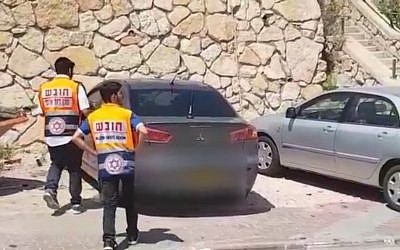 Two paramedics in the northern town of Rechasim where a baby boy died after being left in a car. (Screen capture: Ynet news)