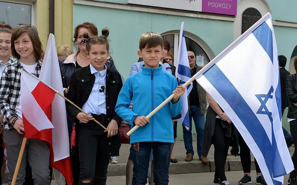 Local children hold Polish and Israeli flags in Plonsk, Poland, the birthplace of first Israeli prime minister David Ben-Gurion, in celebration of Israel's 70 years of independence, April 15, 2018.  (Yossi Zeliger/Limmud FSU)