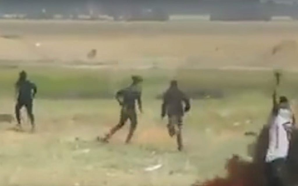 A Palestinian demonstrator raises his hands moments before falling to the ground, reportedly after being shot by IDF soldiers (screenshot)