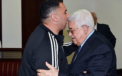 Palestinian Authority President Mahmoud Abbas (r), welcomes Rajaei Haddad, who spent 20 years in the Israeli prisons for his involvement in a 1997 terror attack which killed Gabriel Hirschberg. (WAFA/Thaer Ghanaim)