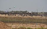 Illustrative: Palestinians try to use a kite to fly a Molotov Cocktail toward IDF troops along the Gaza fence on April 13 2018. (Israel Defense Forces)