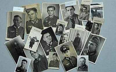Photographs of missing former German soldiers lie on a table at the German Red Cross archive in Munich, southern Germany, on April 9, 2018.  (AFP PHOTO / Christof STACHE)