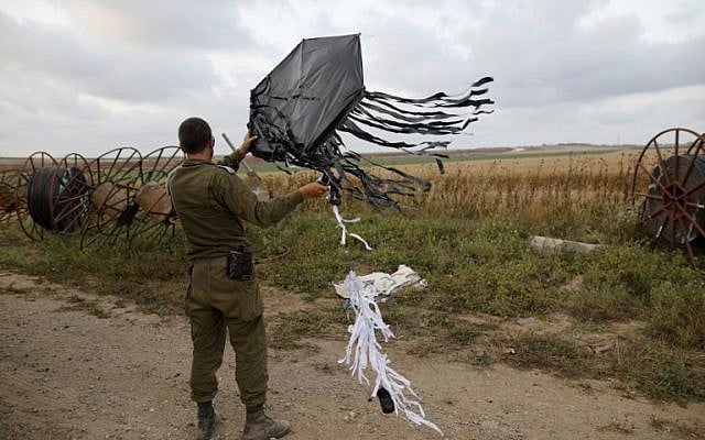 An Israeli soldier holds a kite flown over the border from Gaza in a tactic recently used by Palestinian protesters to start fires in Israeli on the Israel-Gaza border near the kibbutz of Kfar Aza on April 24, 2018. (AFP PHOTO / Menahem KAHANA) An Israeli soldier holds a kite flown over the border from Gaza in a tactic recently used by Palestinian protesters to start fires in Israeli on the Israel-Gaza border near the kibbutz of Kfar Aza on April 24, 2018. (AFP PHOTO / Menahem KAHANA)