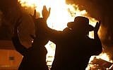 Ultra-Orthodox Jews dance around a bonfire in Jerusalem's Mea Shearim neighborhood on May 2, 2018, during celebrations for the Jewish holiday of Lag BaOmer. (AFP PHOTO / MENAHEM KAHANA)