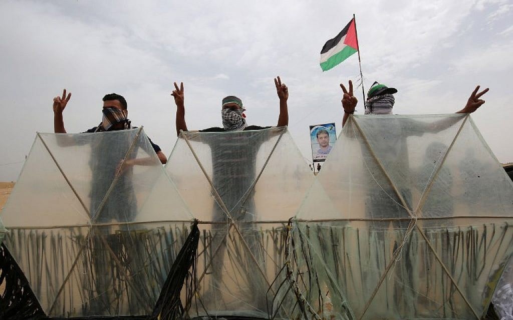 Palestinians pose behind kites before trying to fly them over the border fence with Israel, in Khan Younis in the southern Gaza Strip on May 4, 2018. Palestinians taking part in weekly clashes on the border have adopted a new tactic of attaching firebombs to kites to fly over the border fence into Israel. (AFP Photo/Said Khatib) Palestinians pose behind kites before trying to fly them over the border fence with Israel, in Khan Younis in the southern Gaza Strip on May 4, 2018. Palestinians taking part in weekly clashes on the border have adopted a new tactic of attaching firebombs to kites to fly over the border fence into Israel. (AFP Photo/Said Khatib)