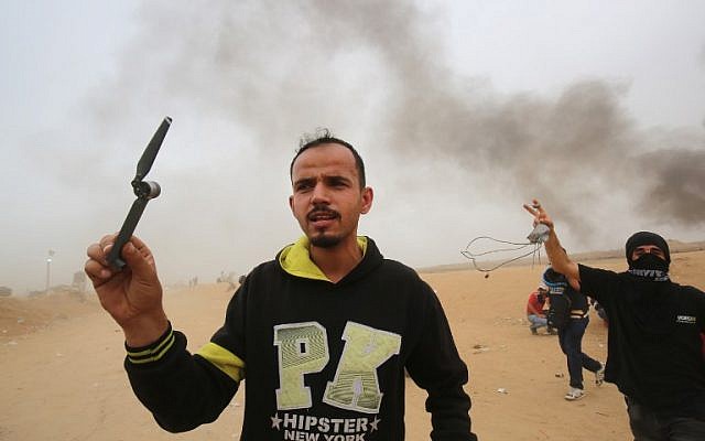 A Palestinian holds what he says is a part of a propeller of an IDF army drone, east of Khan Younis in the southern Gaza Strip, on May 4, 2018. (Said Khatib/AFP)