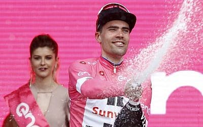 Dutch cyclist Tom Dumoilin of team Sunweb celebrates on the podium with the overall leader's pink jersey after winning the 1st stage of the 101st Giro d'Italia, on May 4, 2018, in Jerusalem. (AFP Photo/Luk Benies)