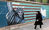 An Iranian woman walks past a mural on the wall of the former US embassy in the Iranian capital Tehran on May 8, 2018. (AFP / ATTA KENARE)