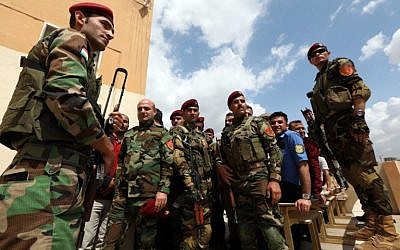 Iraqi Kurdish security members line up in front of a polling station to vote ahead of parliamentary elections in Arbil, the capital of the Kurdish autonomous region in northern Iraq on May 10, 2018. (AFP Photo/Safin Hamed)