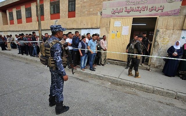 Members of the Iraqi security forces stand guard as people line up in front of a polling station in the Wadi Hajar district of Mosul on May 12, 2018. (AFP Photo/Ahmad al-Rubaye) Members of the Iraqi security forces stand guard as people line up in front of a polling station in the Wadi Hajar district of Mosul on May 12, 2018. (AFP Photo/Ahmad al-Rubaye)