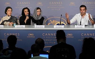(From L) Iranian actress Behnaz Jafari, a translator, Iranian actress Marziyeh Rezaei, the empty seat of Iranian director Jafar Panahi and Iranian director of photography Amin Jafari attend on May 13, 2018 a press conference for the film 'Three Faces (Se Rokh)' at the 71st edition of the Cannes Film Festival in Cannes, southern France.  (AFP PHOTO / Laurent EMMANUEL)