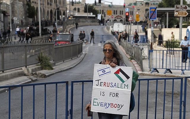 A woman holds a banner at Damascus gate ahead of the Jerusalem Day celebrations marking the unification of the city during the Six Day War, May 13, 2018. (Ahmad GHARABLI/AFP)