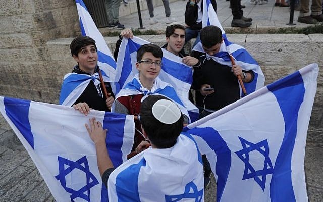 Israeli youths hold their national flag during a march to celebrate Jerusalem Day, marking the unification of the city during the Six Day War, May 13, 2018.  (Thomas COEX/AFP)
